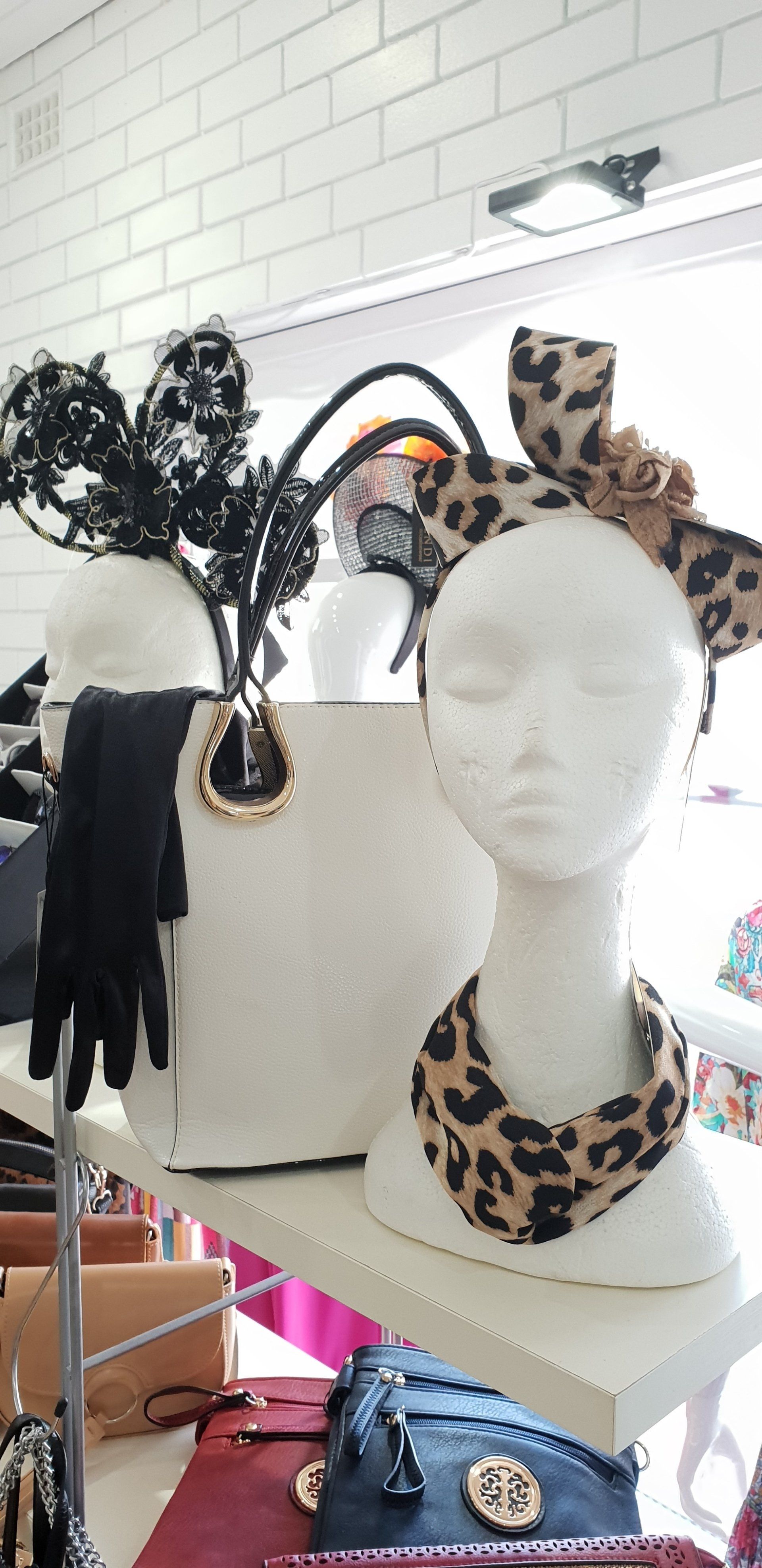 Display of accessories: white bag, leopard print headband, and a black glove.