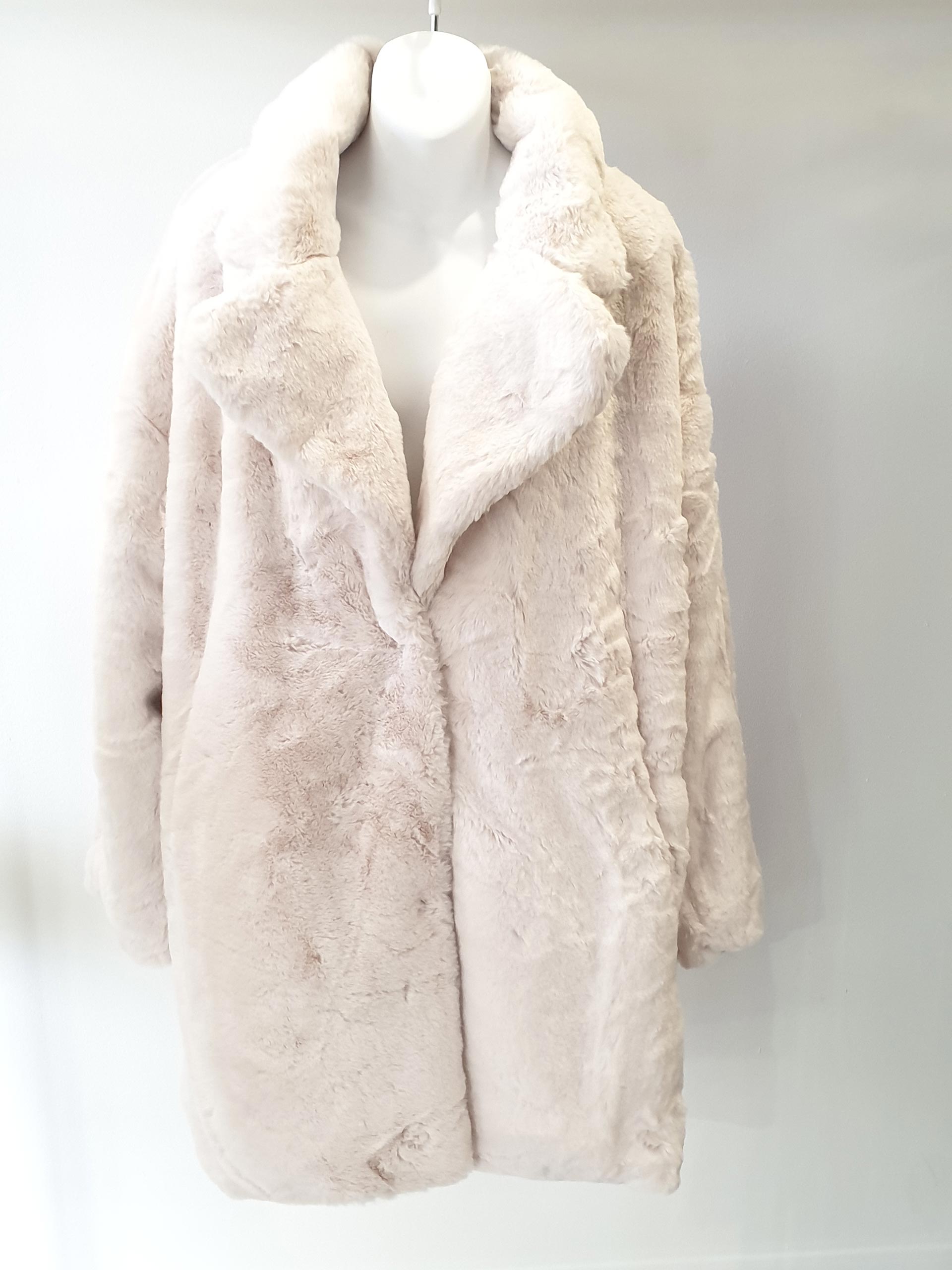 Pale pink faux fur coat on a white mannequin against a white background.