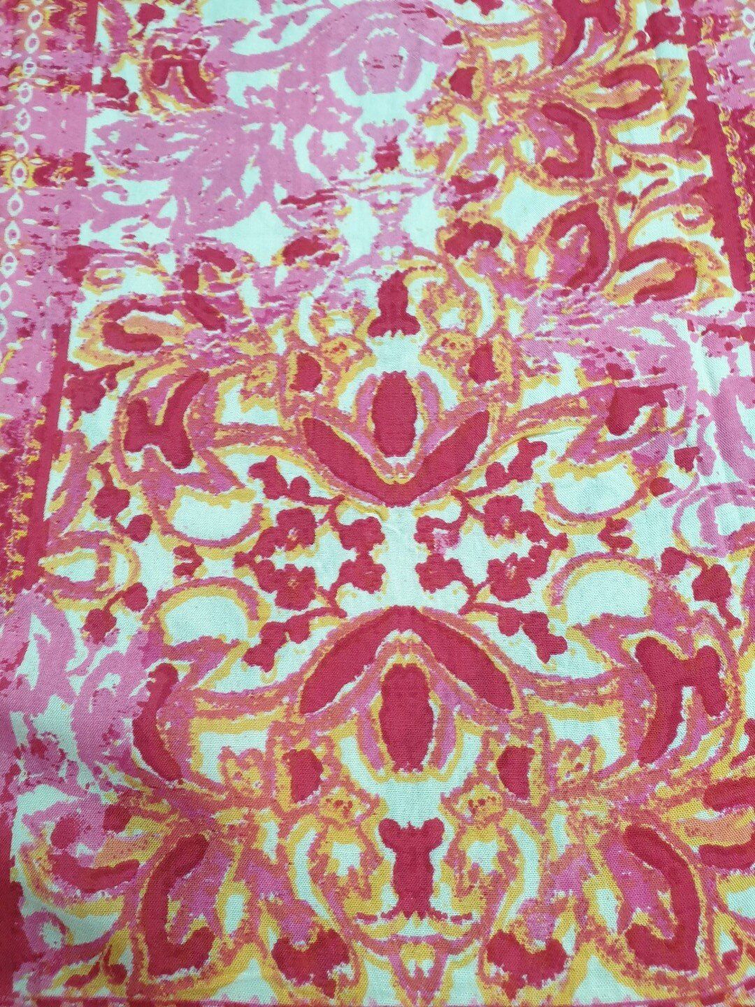 Pink, red, and orange floral damask pattern on a white background.
