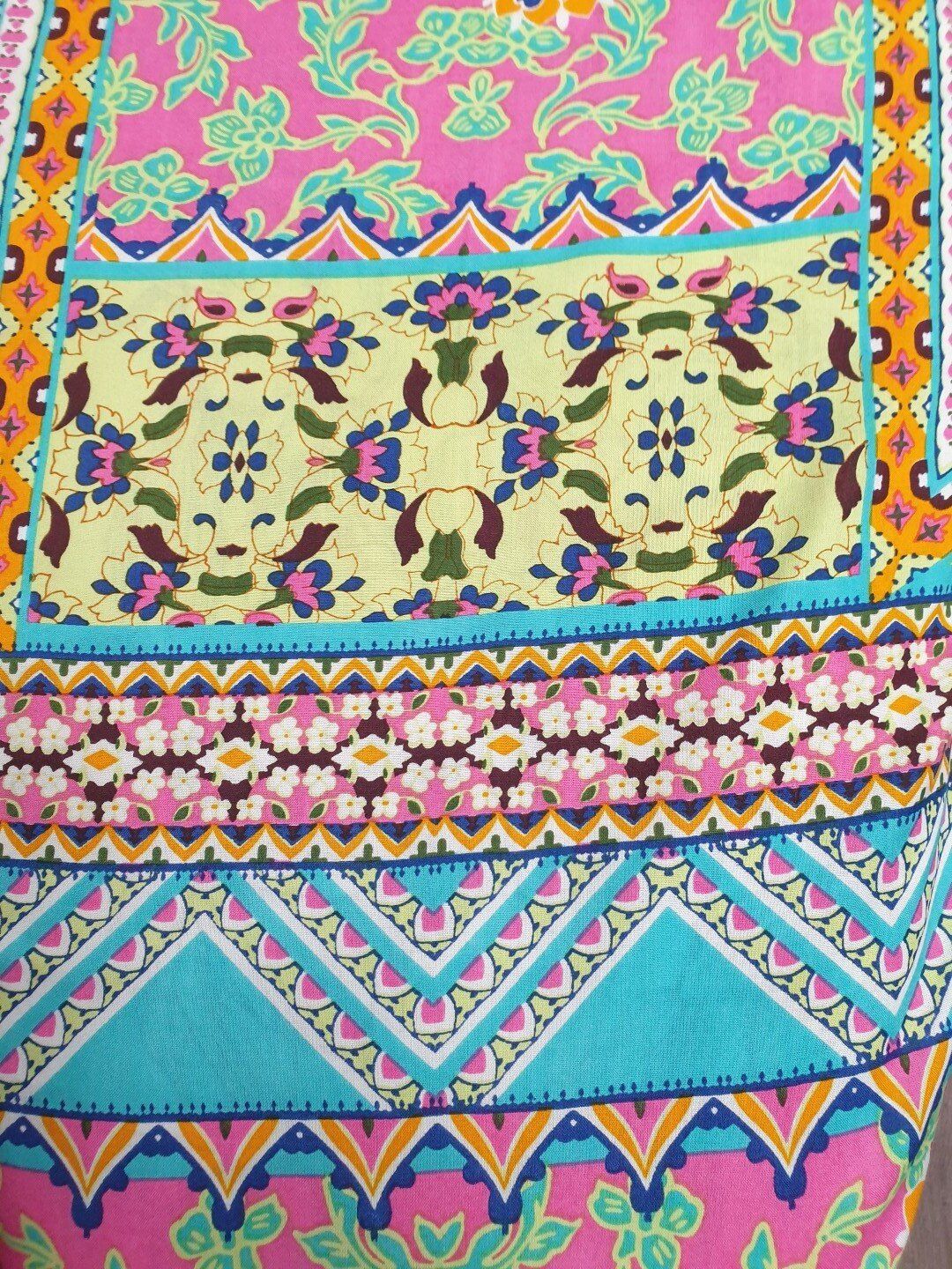 Brightly patterned fabric with pink, blue, yellow, and orange floral and geometric designs.