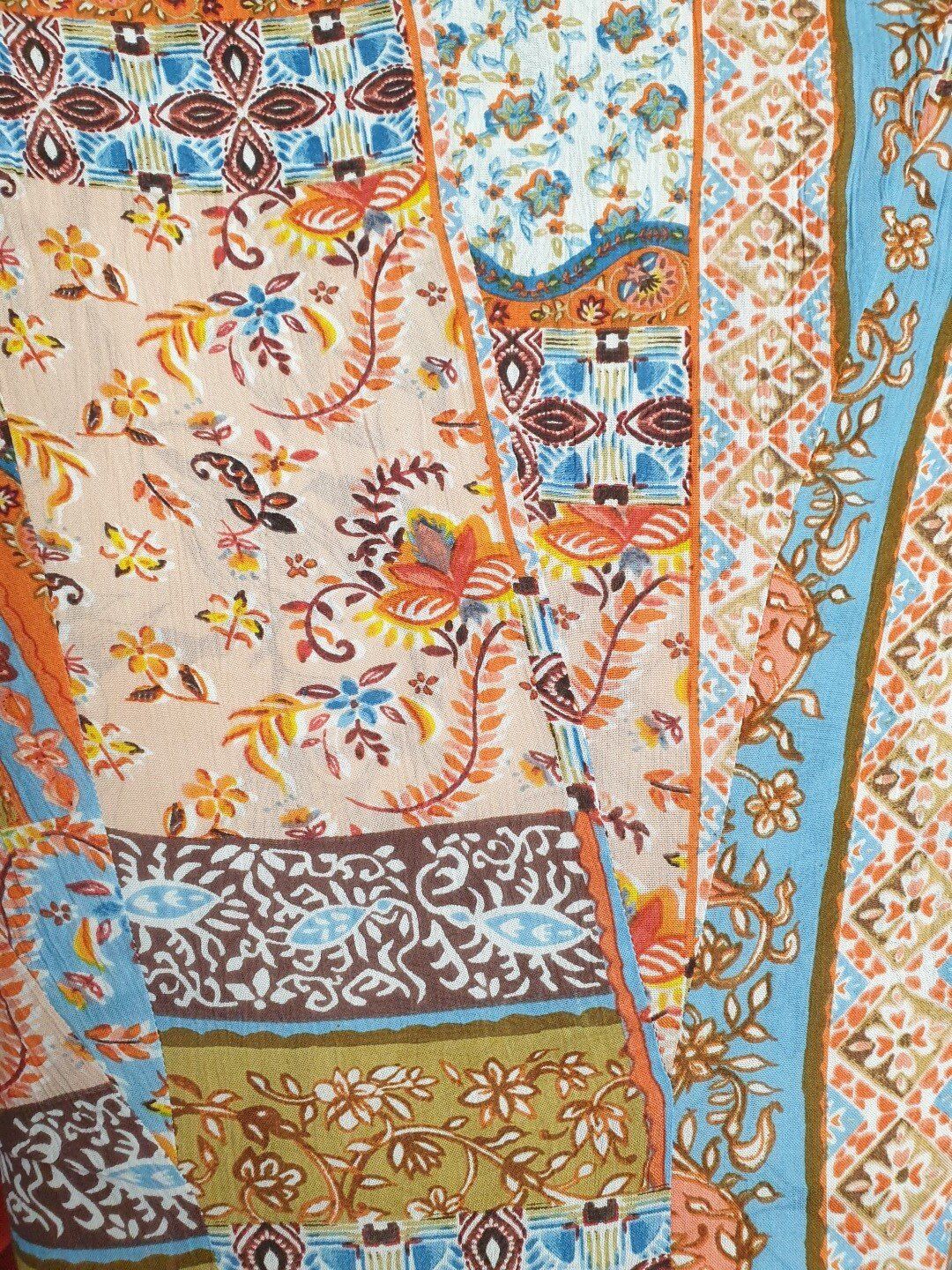Patchwork fabric with floral and geometric patterns in orange, brown, and blue.