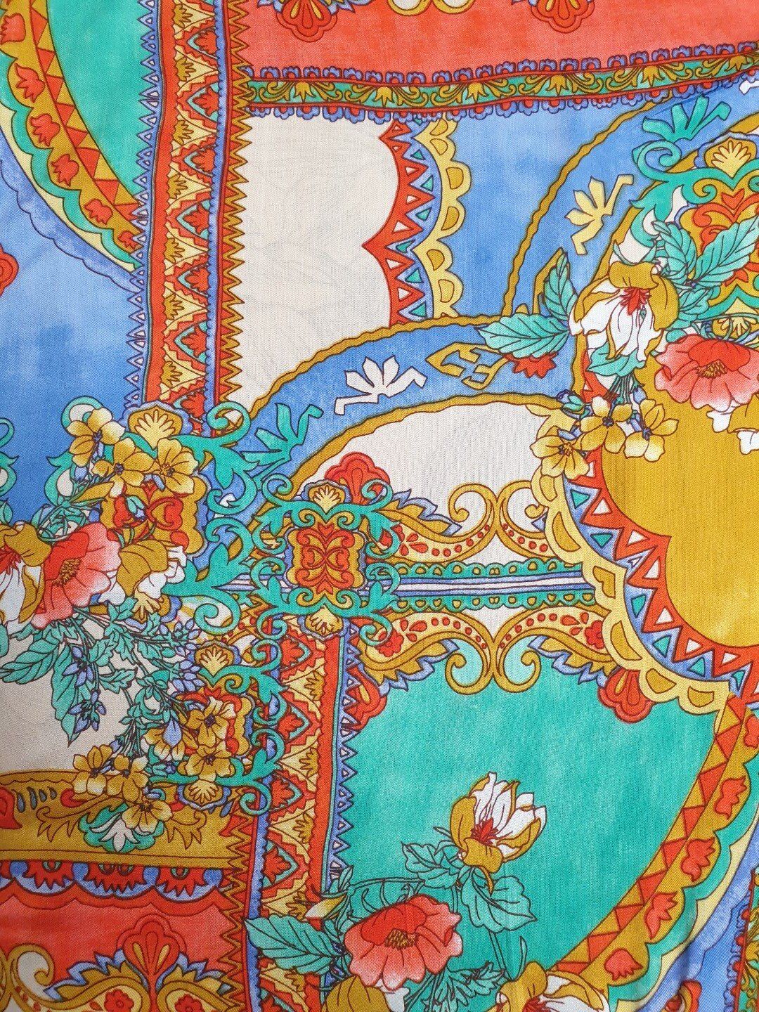 Colorful floral fabric with blue, red, yellow, and teal patterns.