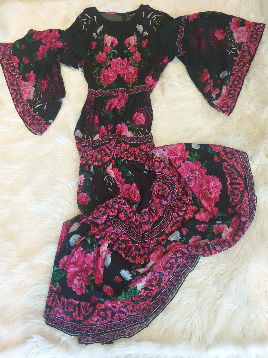 Black floral dress with flared sleeves and a floor-length skirt, featuring pink roses and detailing.