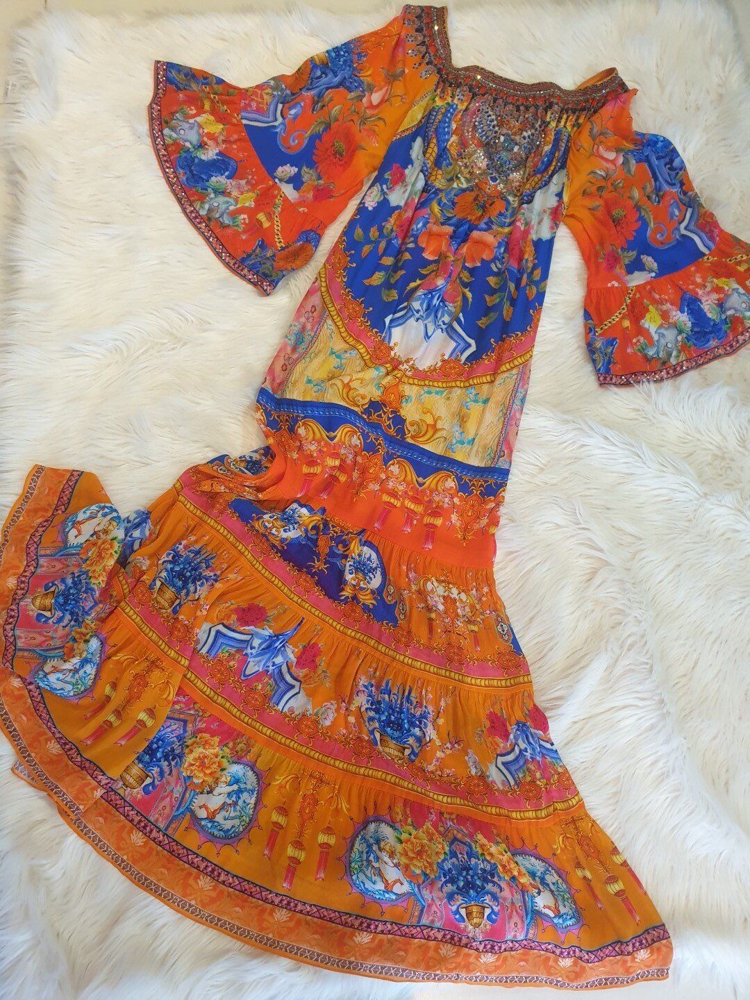 Orange bohemian dress with blue floral print, off-the-shoulder, bell sleeves, flowing skirt.