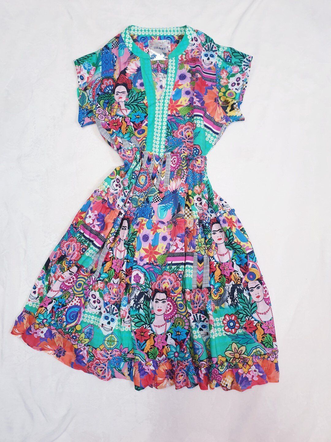 Colorful Frida Kahlo print dress with a teal neckline.
