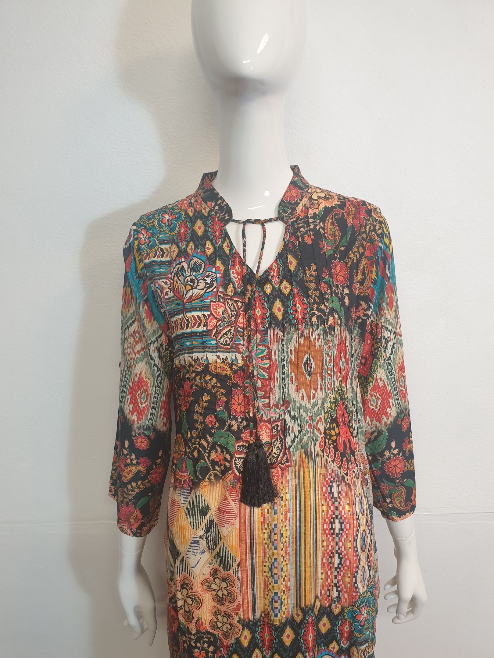 Dress on mannequin; black floral pattern with tie at neckline, 3/4 sleeves.