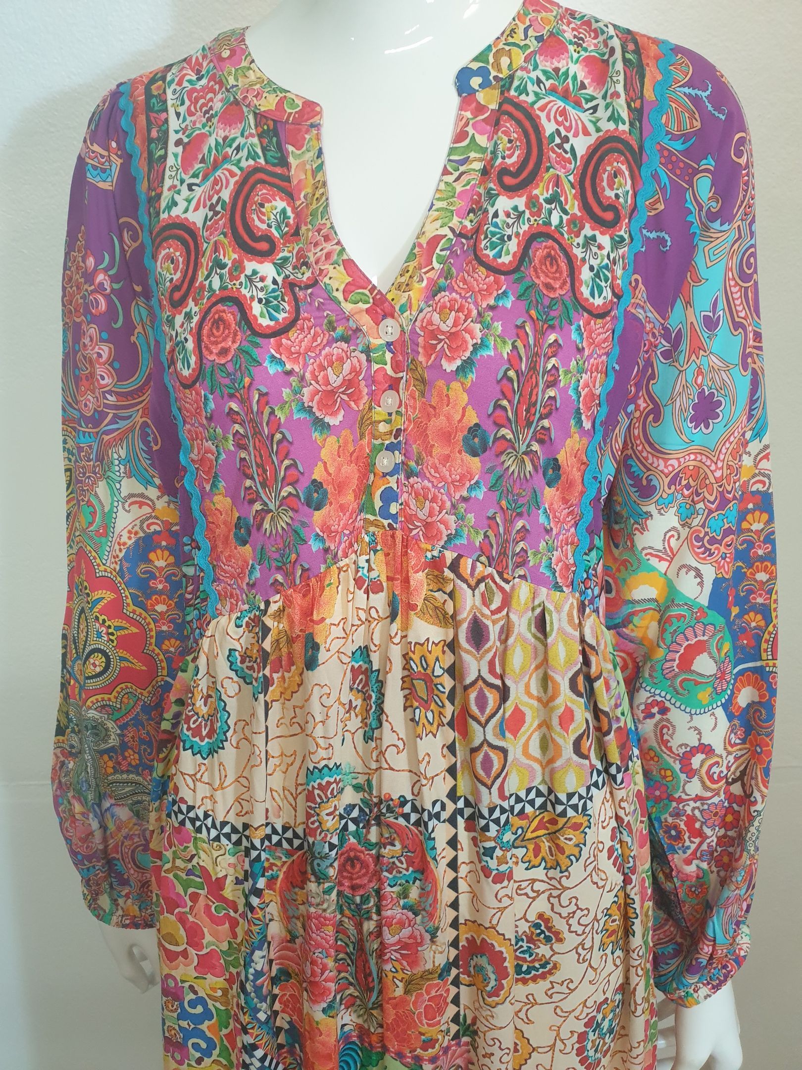 Boho-style maxi dress with colorful paisley and floral print on a mannequin.