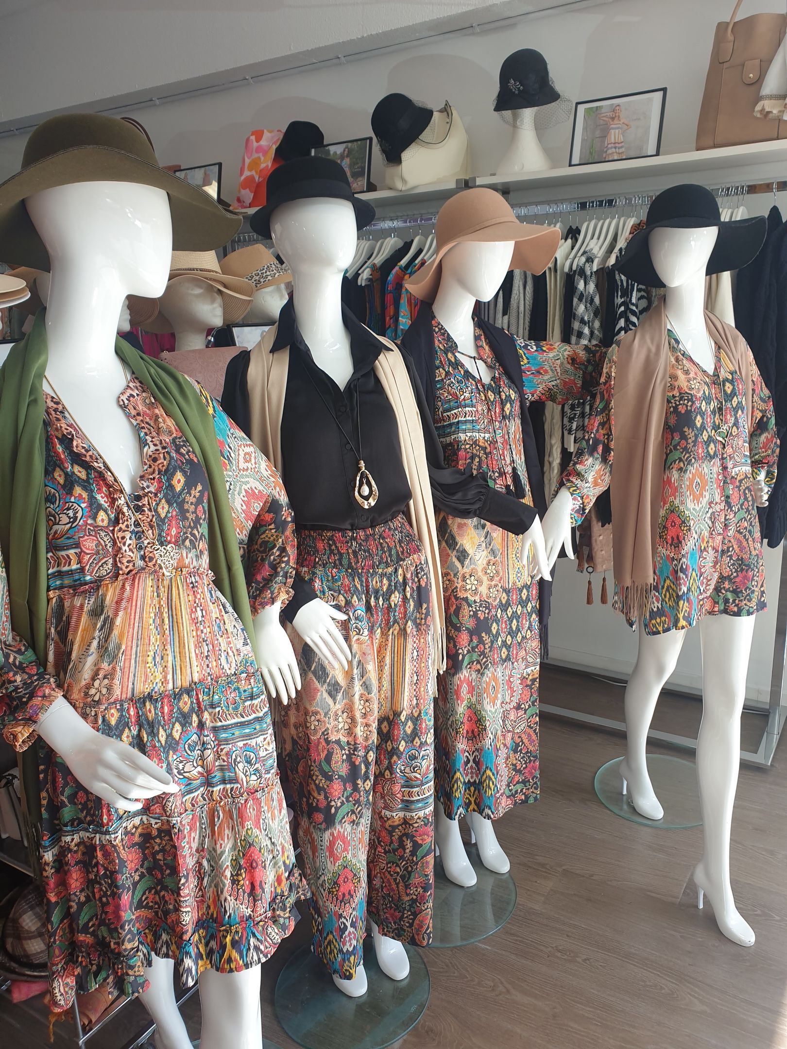 Mannequins wearing colorful floral outfits in a clothing store.