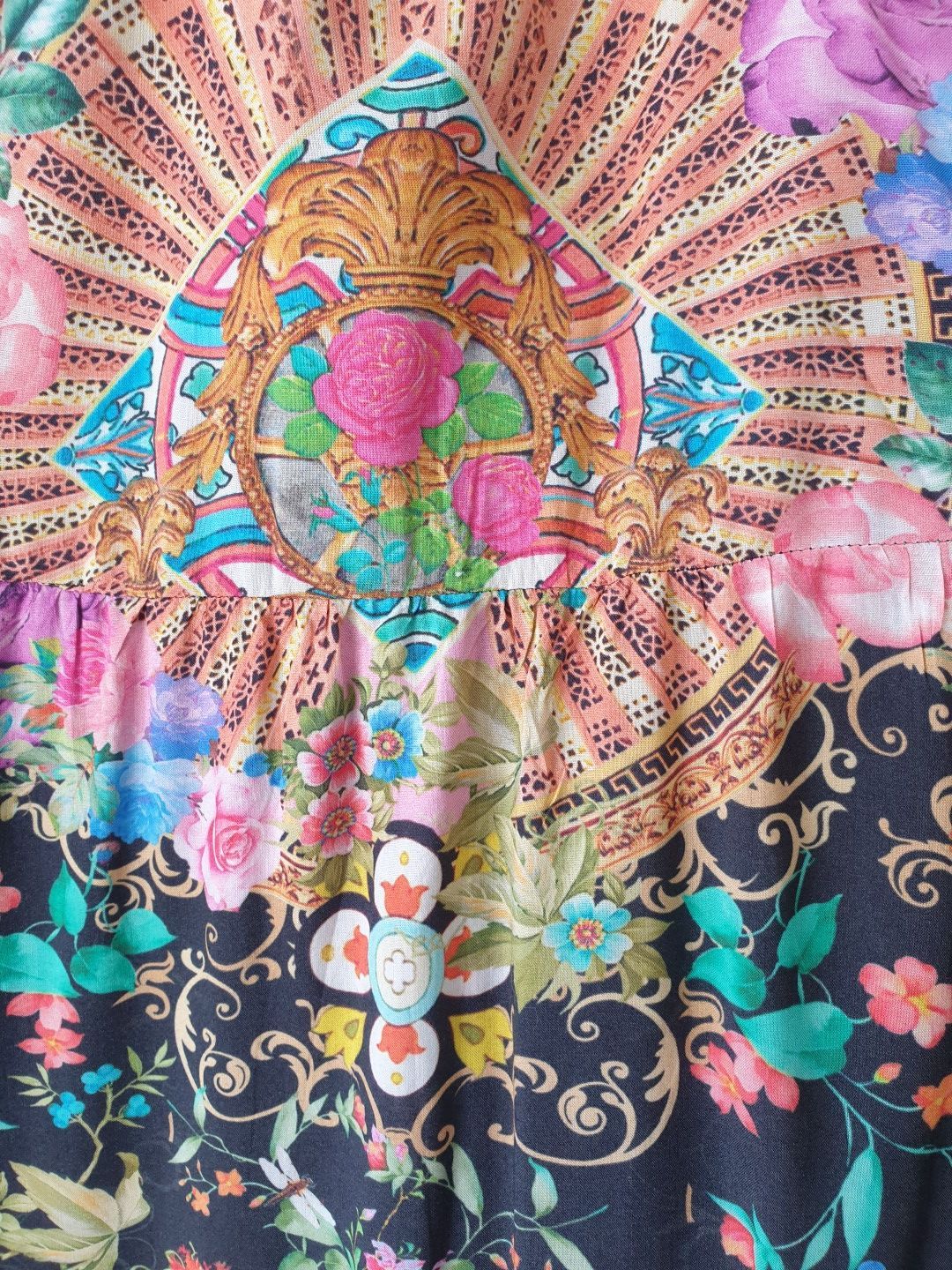 Floral fabric with gold emblem, pink and blue flowers on a dark background.