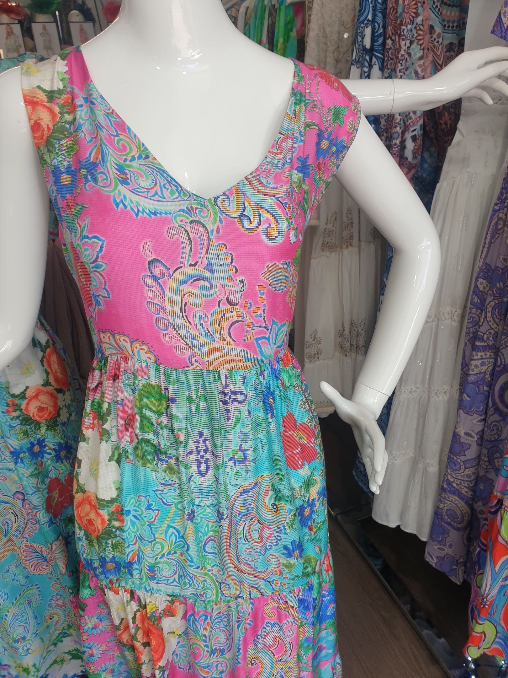 Mannequin wearing a sleeveless floral-print dress with pink, blue, and white colors.