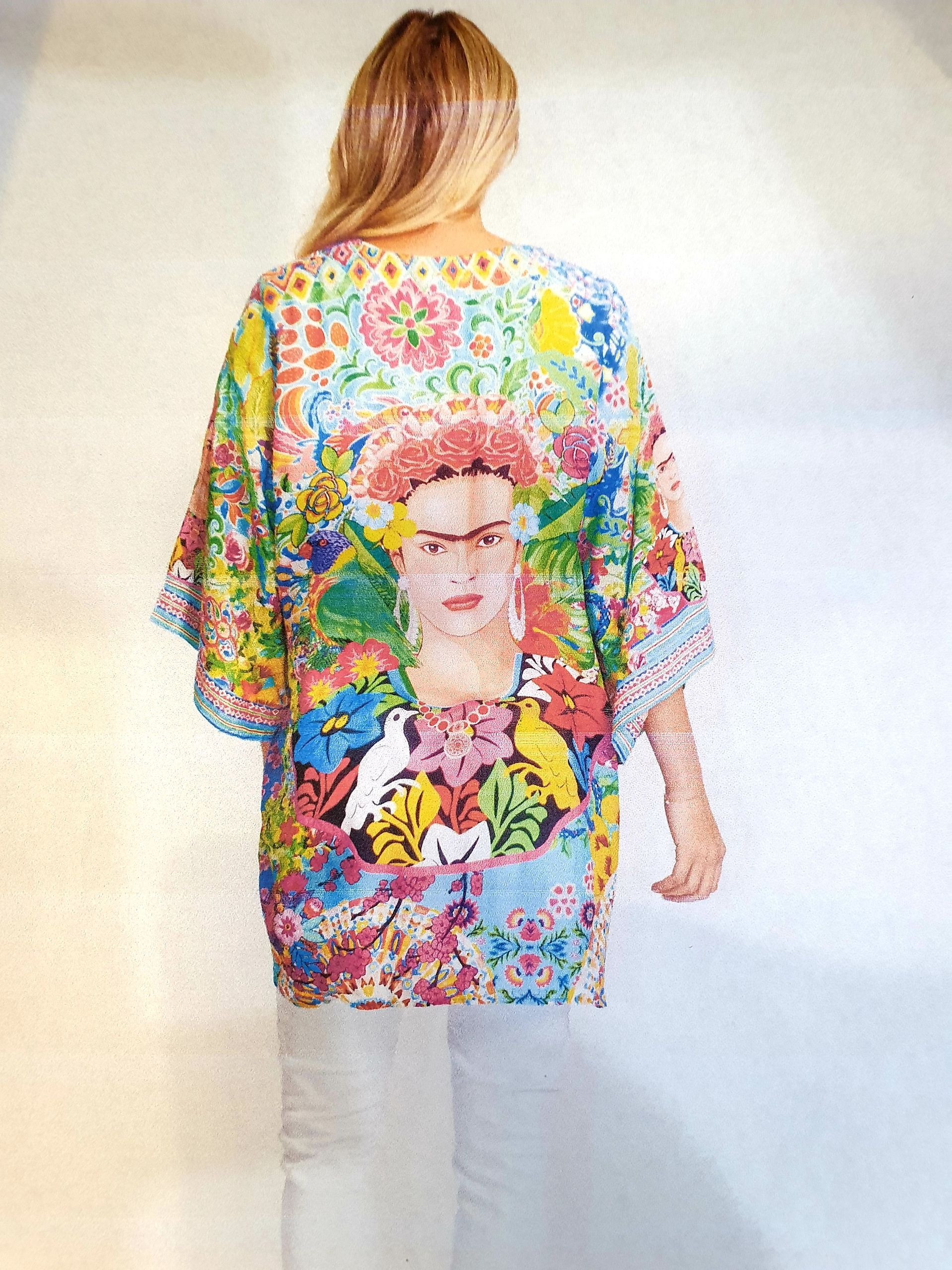 Woman wearing colorful Frida Kahlo art kimono, standing.