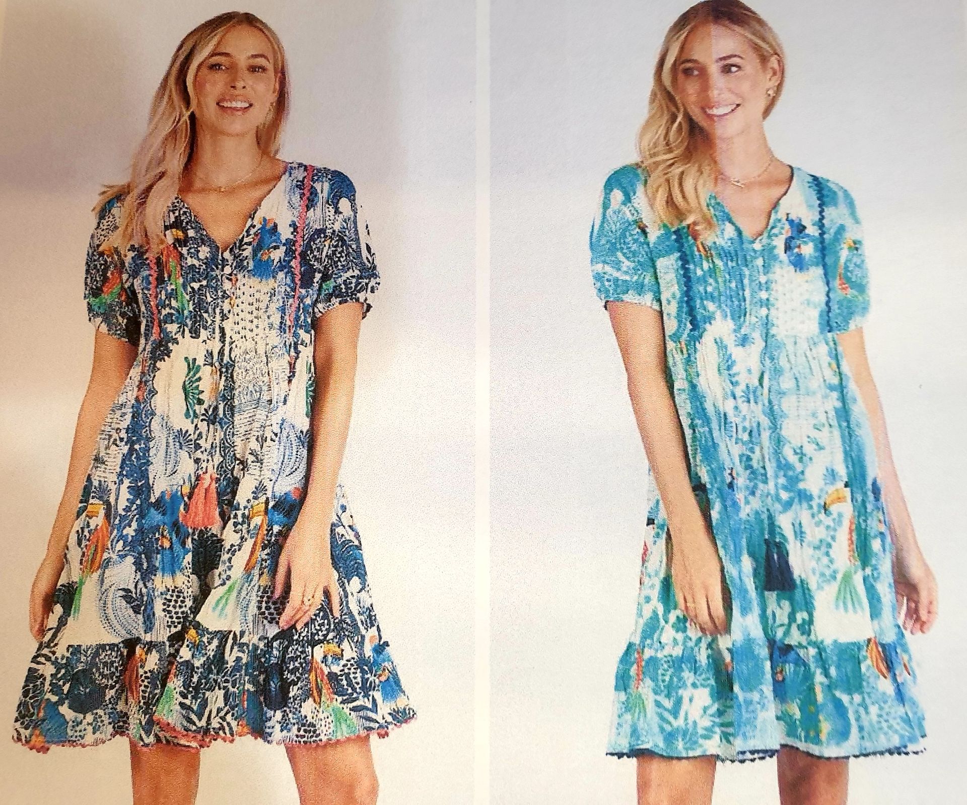 Two women wearing floral print dresses with tassels, smiling.