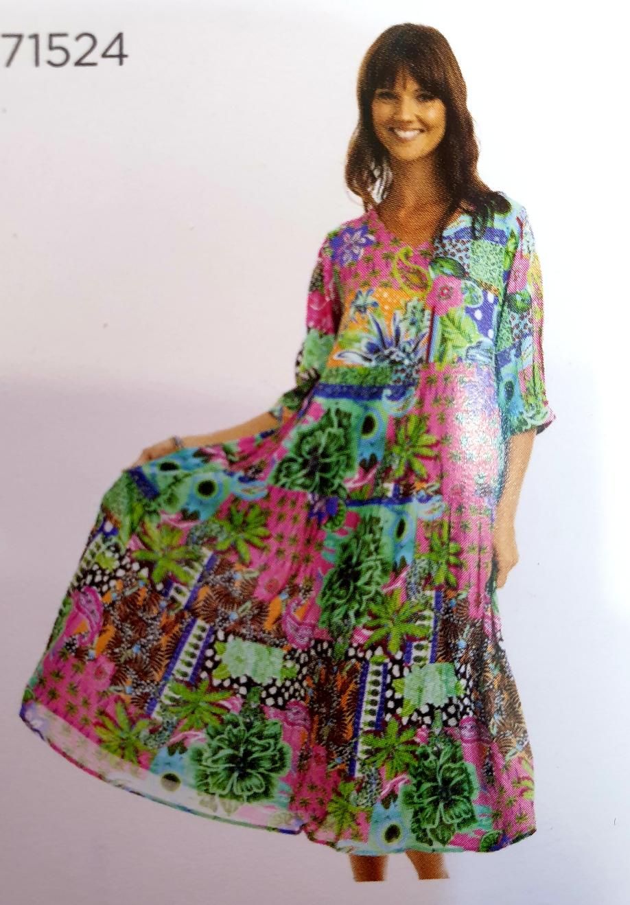 Woman in a colorful floral patterned dress smiling, standing outdoors.