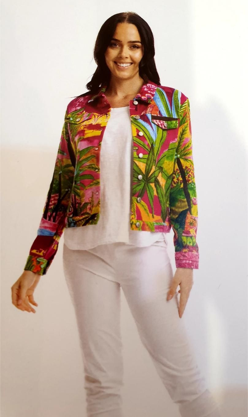 Woman wearing a colorful floral jacket, white top, and pants, smiling.