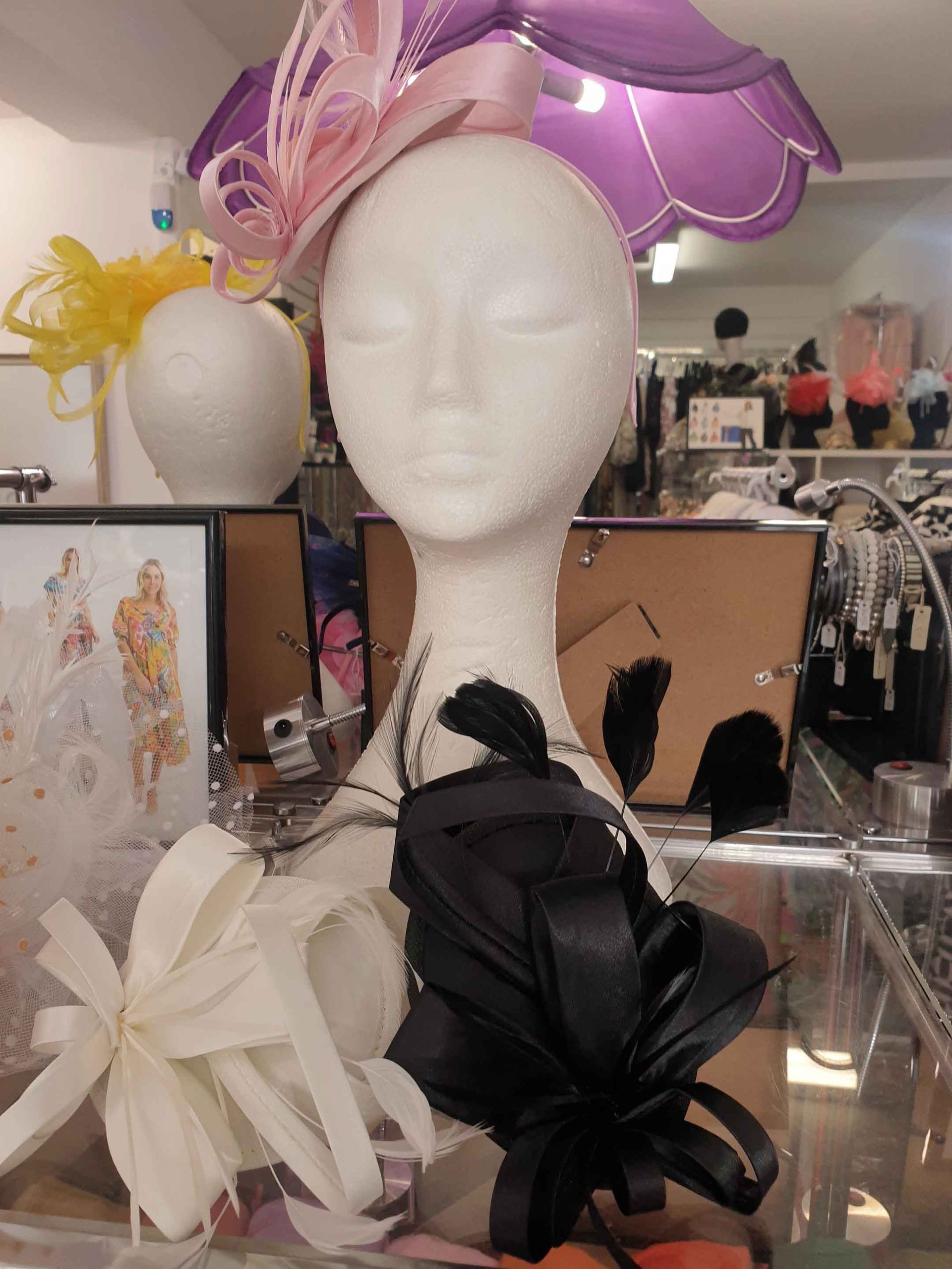 Mannequin head wearing hats, with a shop display background.