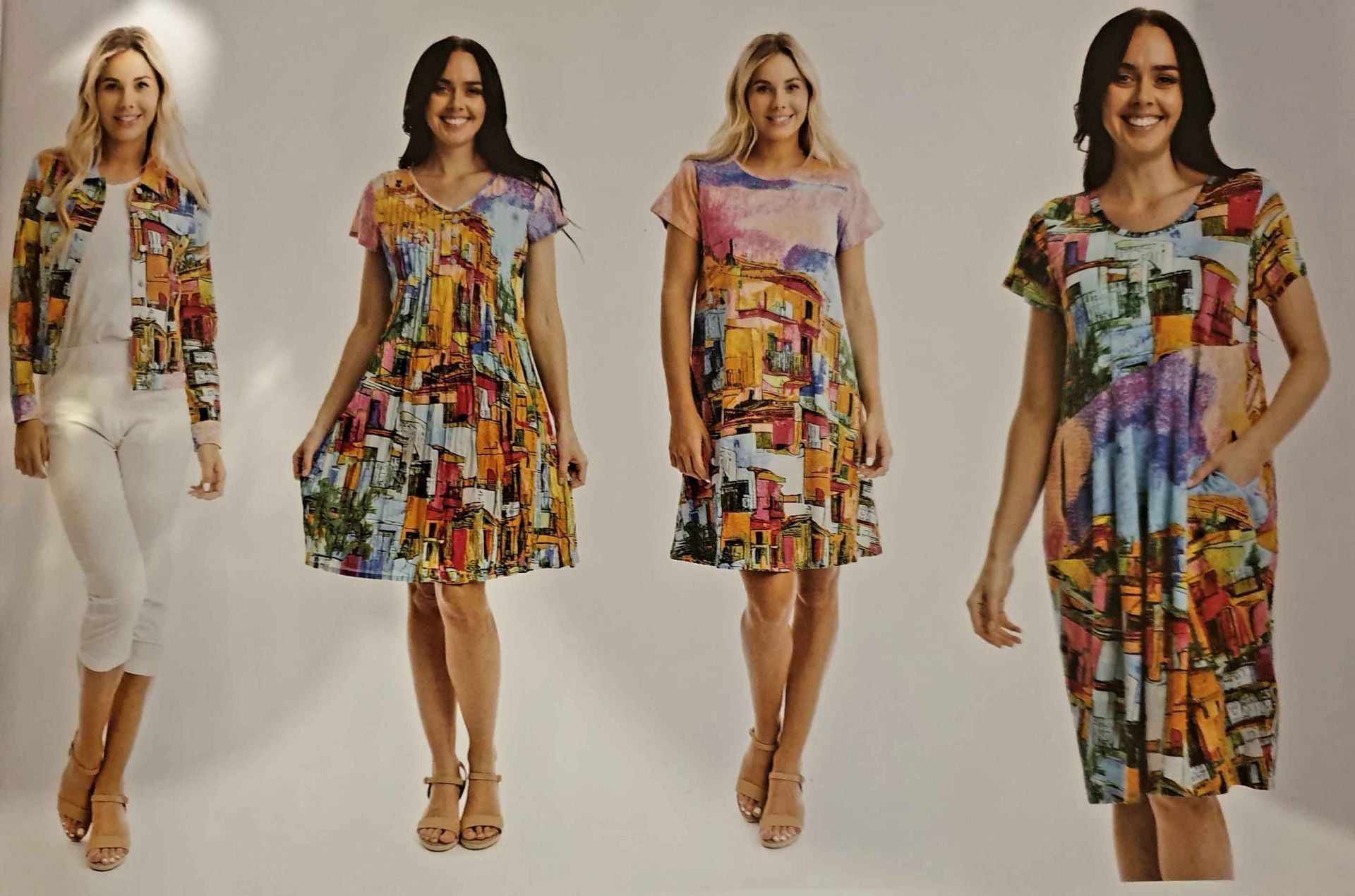 Four women modeling colorful print clothing. Dresses and a jacket.