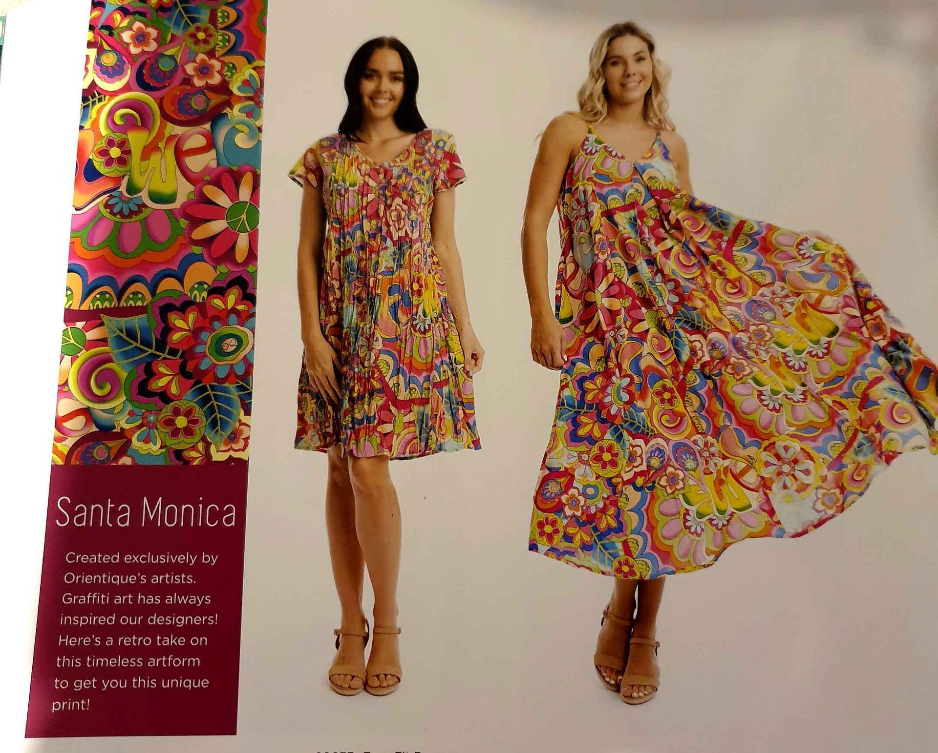 Two women in colorful floral dresses, one with sleeves, the other sleeveless, outdoors with a vibrant pattern.