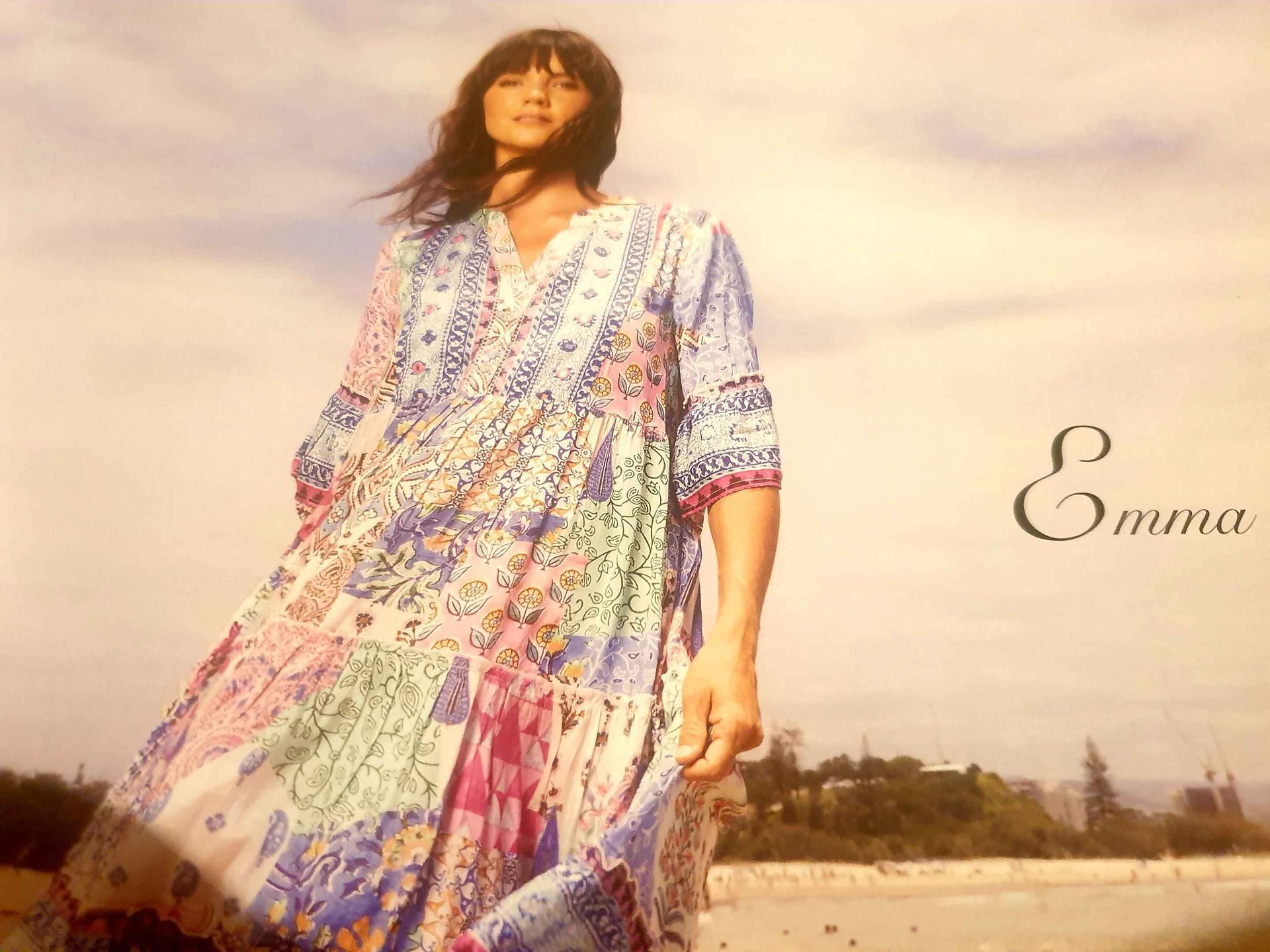 Woman in floral dress, outdoors. Warm light, soft focus. 