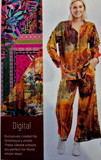 Woman in colorful patterned pantsuit, smiling, with matching fabric detail on the side.