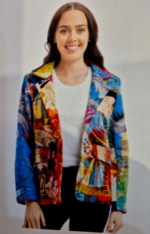 Woman wearing a colorful, patterned blazer over a white shirt and black pants, smiling.