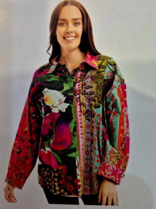Woman wearing a colorful floral print shirt; smiling.