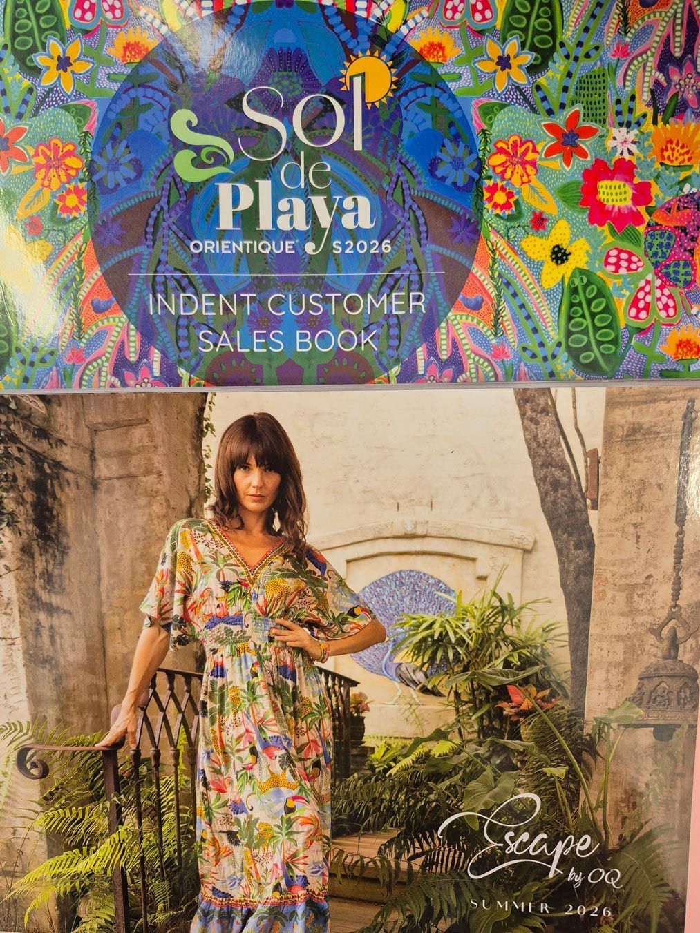 Sol de Playa sales book with a model wearing a floral dress in an outdoor setting.