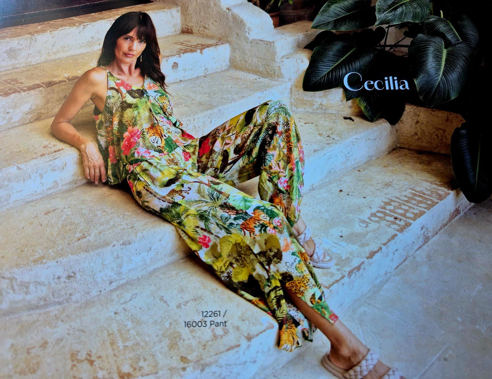 Woman in floral jumpsuit relaxes on stone steps, 