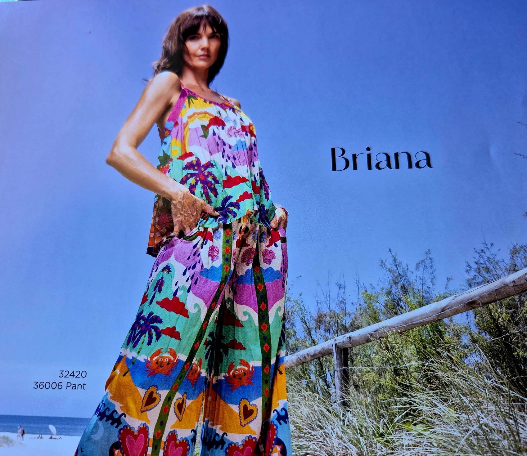 Woman in colorful dress on a beach. Briana label.