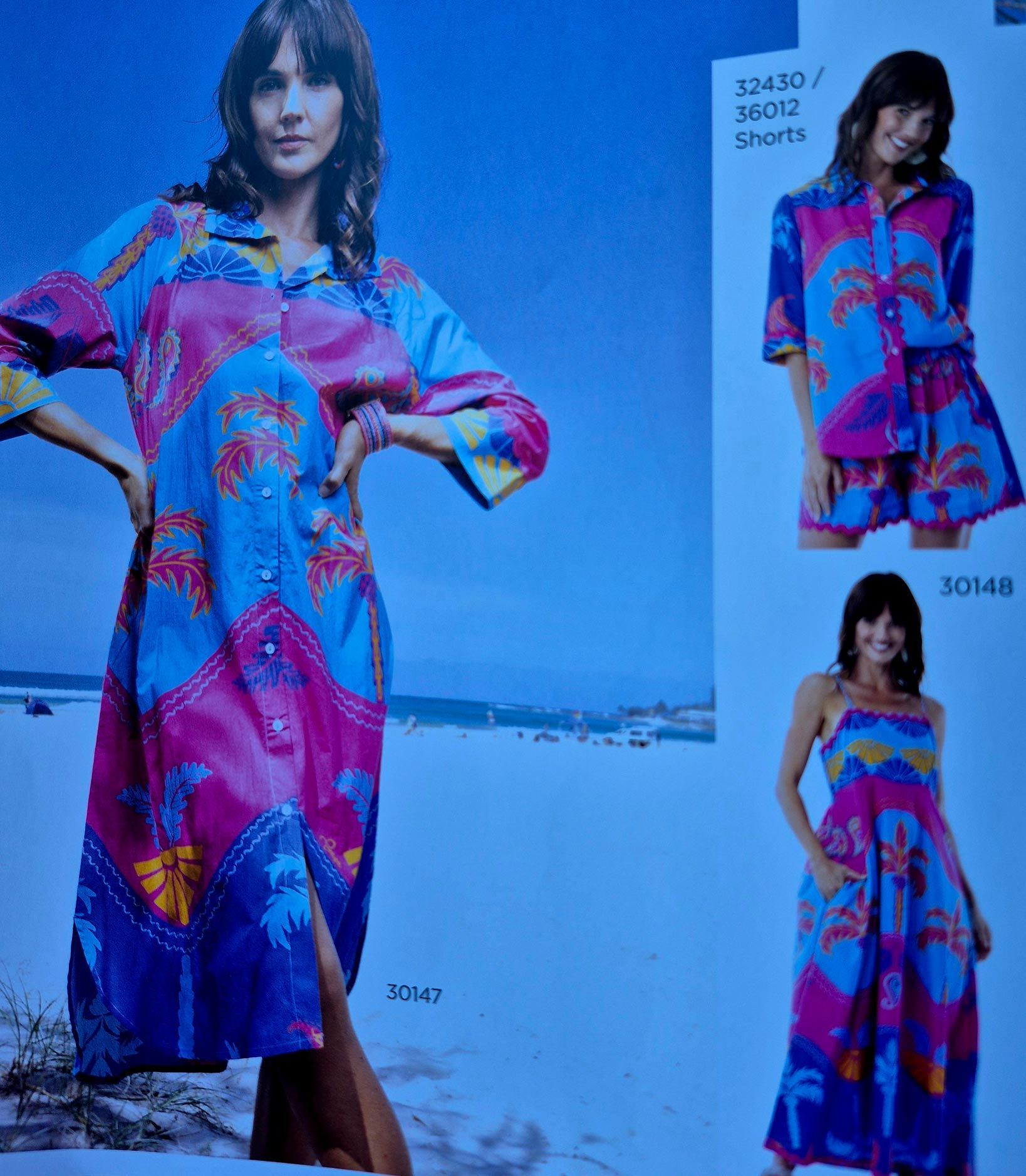 Woman in colorful tropical print dress, smiling. Others in similar patterns, skirt sets, and long dress.