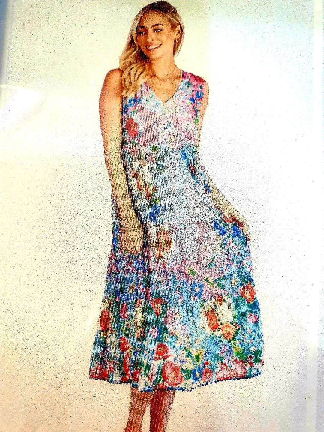 Woman wearing a floral print midi dress, smiling.