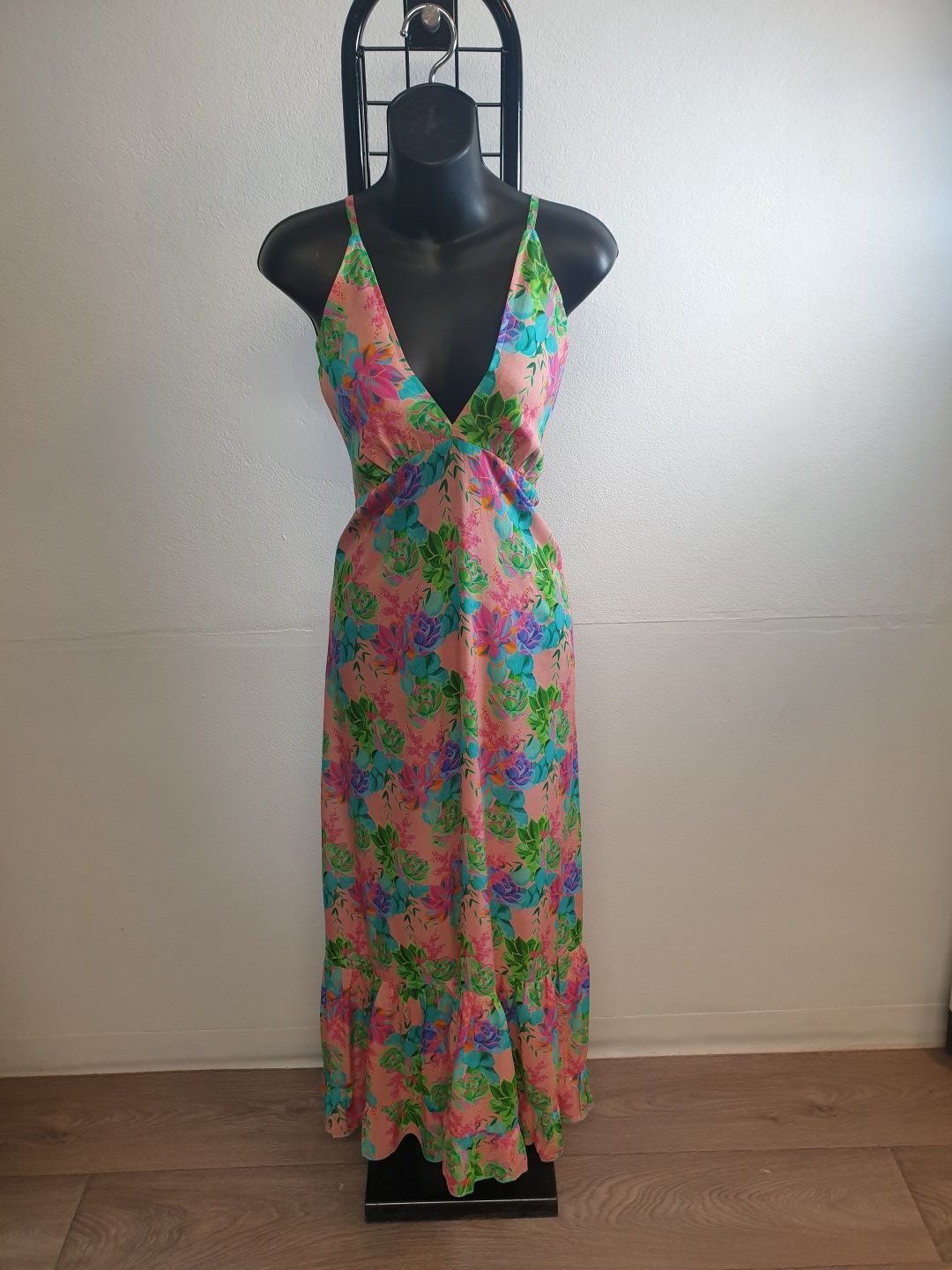 Floral maxi dress on a black mannequin. Pink, blue, and green flowers.