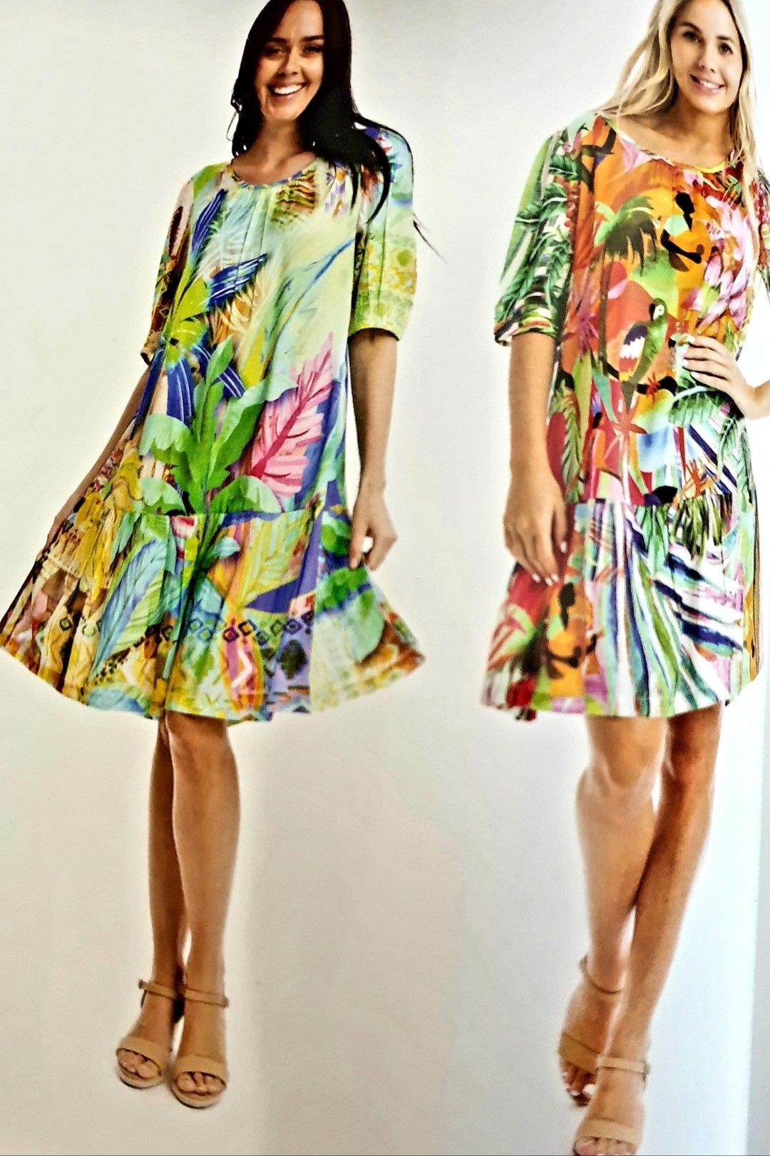 Two women wearing colorful floral dresses with matching heels.