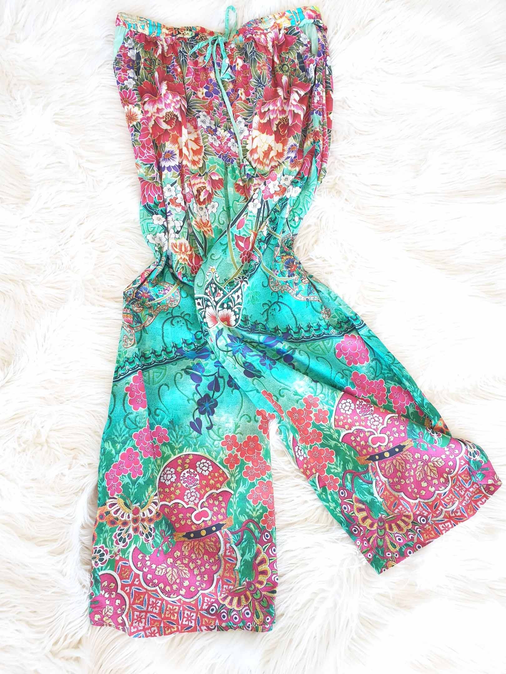 Floral print palazzo pants on a fluffy white surface; turquoise, pink, red.