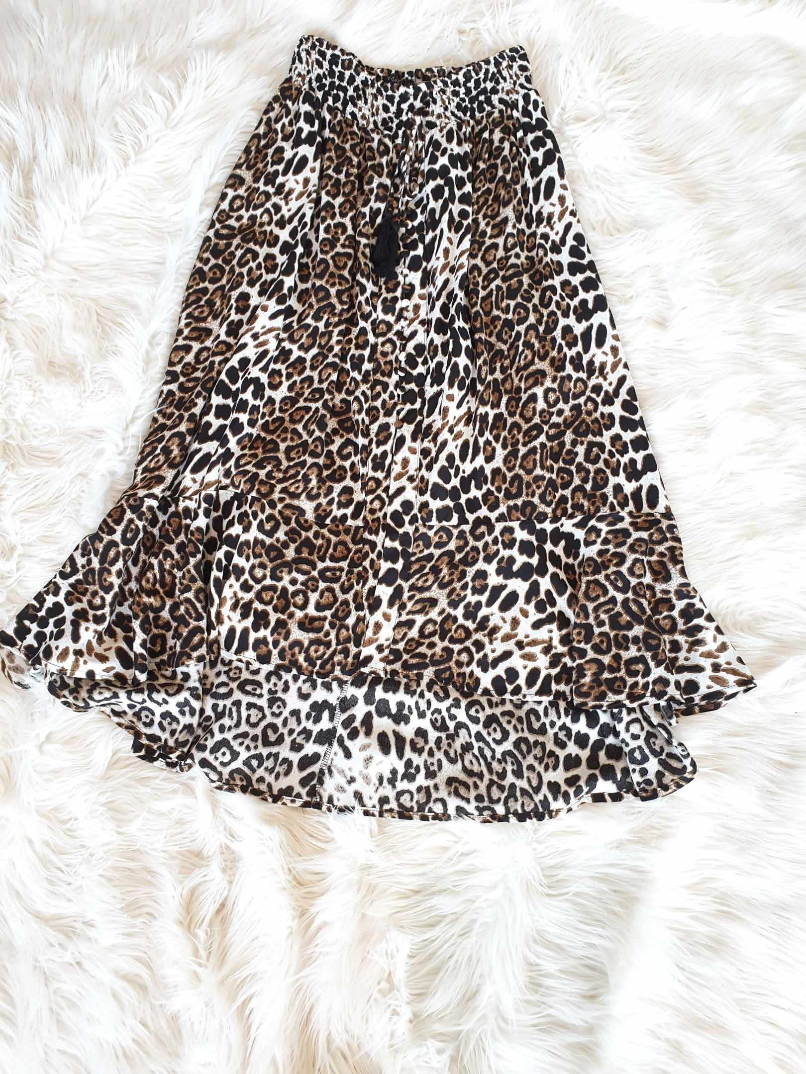 Leopard print maxi skirt with ruffle hem on white fur.
