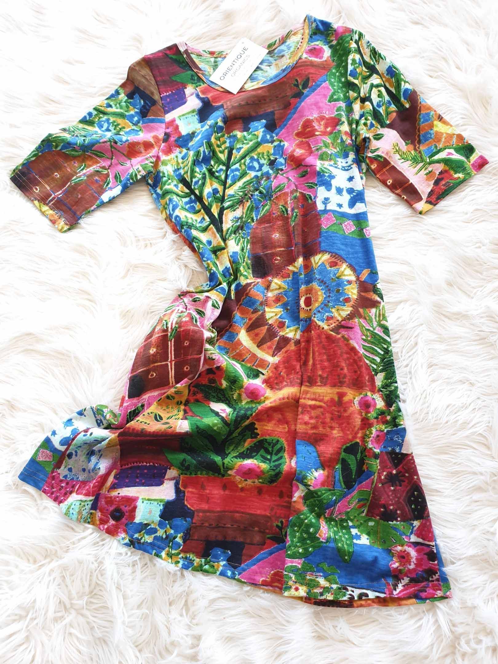 Colorful patterned dress with short sleeves on a white surface.