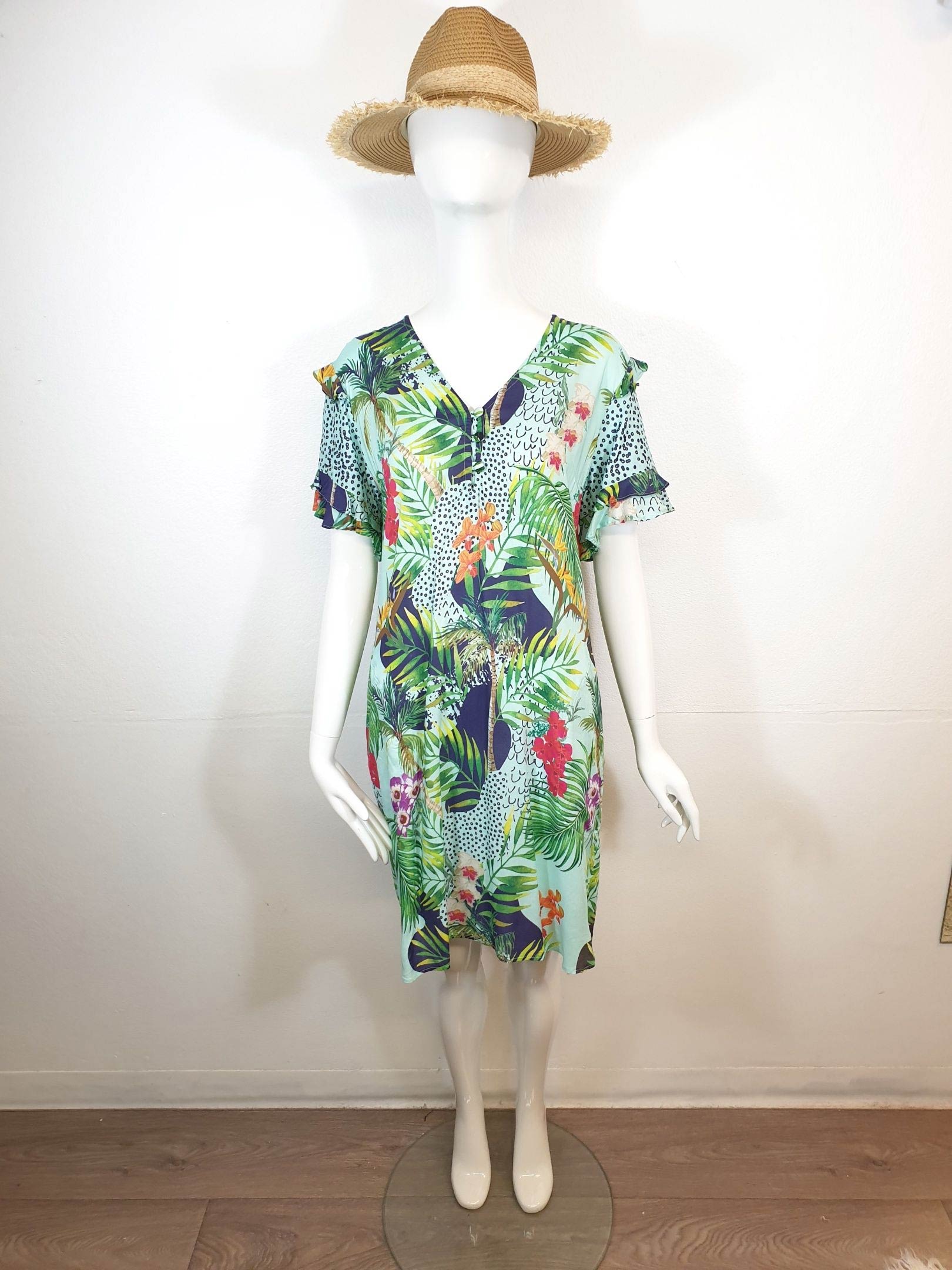 Mannequin wearing a floral print dress and straw hat.