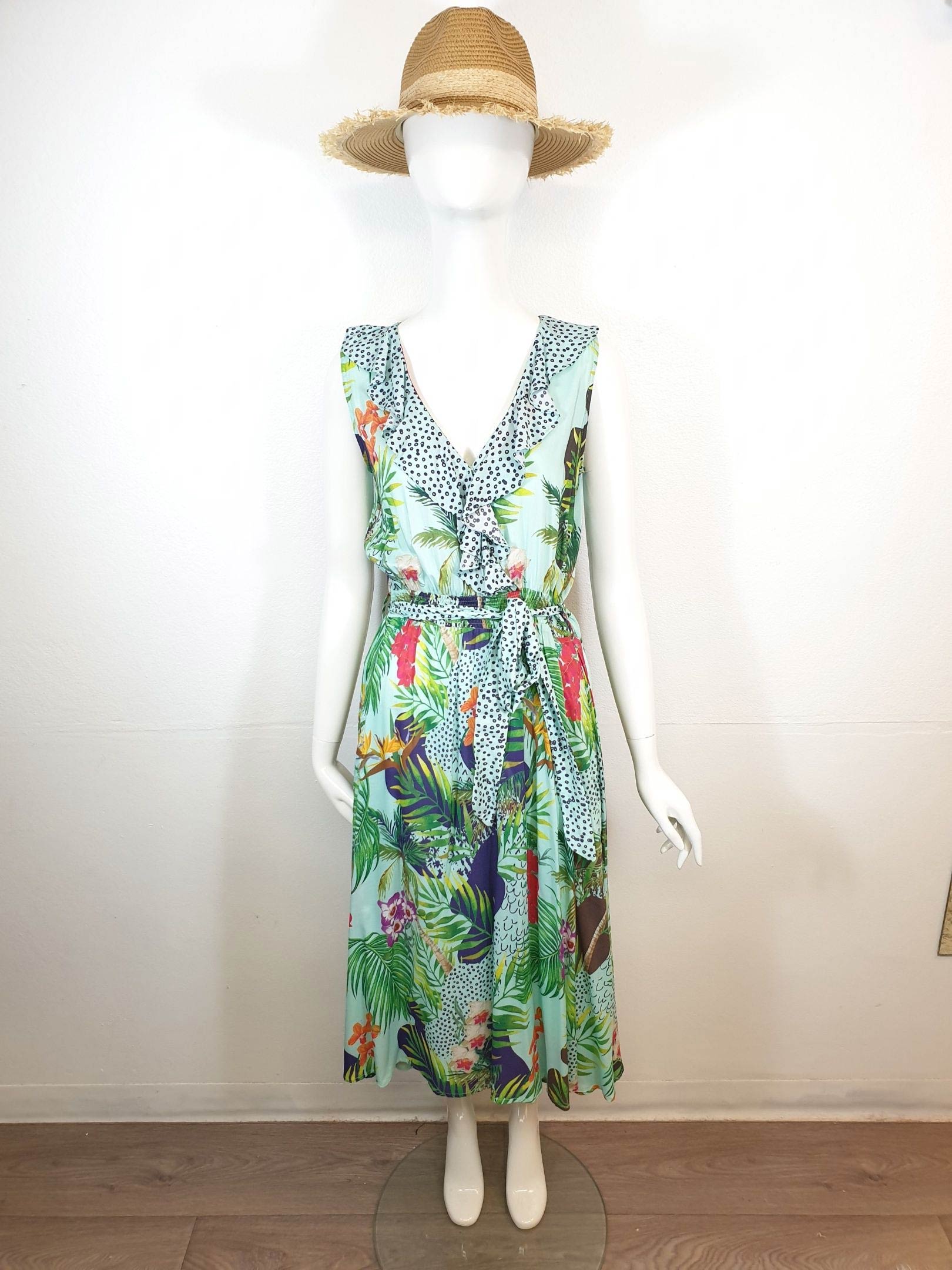 Mannequin wearing a floral print summer dress and straw hat. Light blue dress with green and red accents.