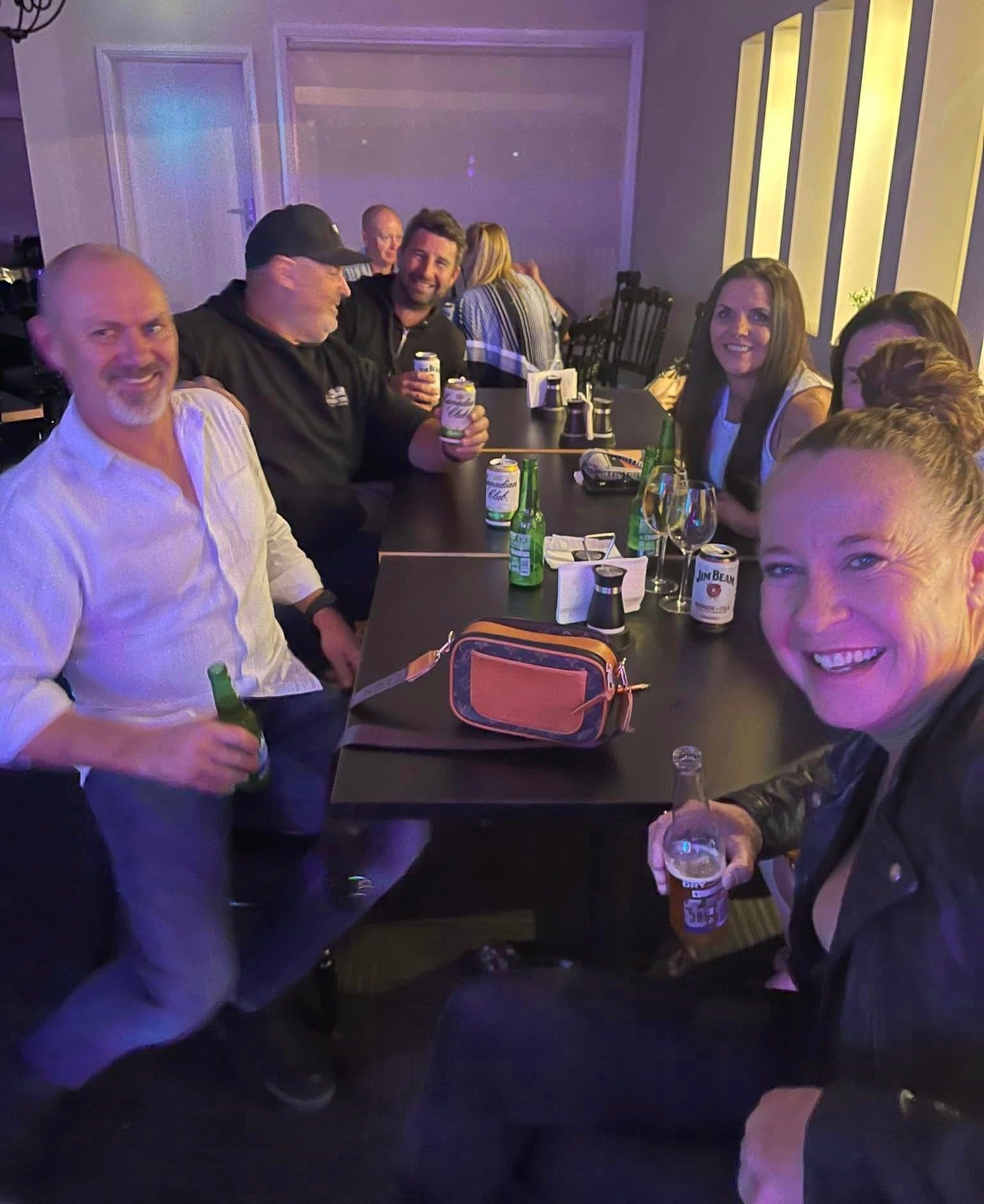 A Group Of People Are Sitting At A Table Drinking Beer — Zeus's Bar & Grill In Tullimbar, NSW