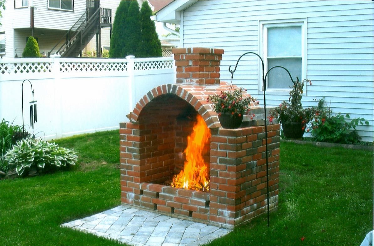 Stone fireplace with wood-burning stove and black chimney, decorated with rustic accents.