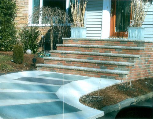Brick steps leading up to a front door with a curved concrete walkway.