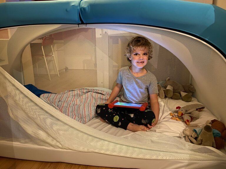 Child on tablet device in CloudCuddle bed