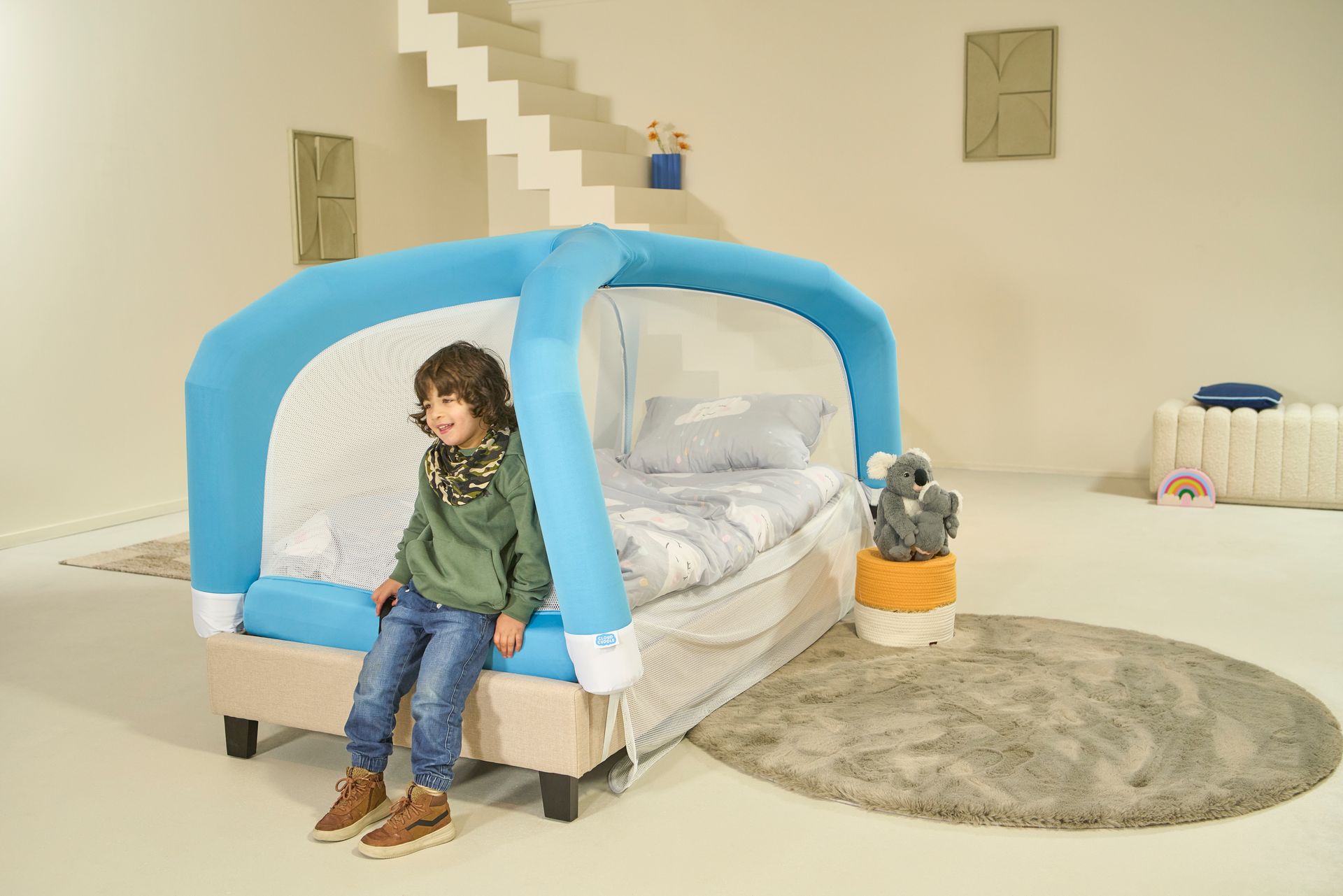 Child sitting on a CloudCuddle Junior bed tent.