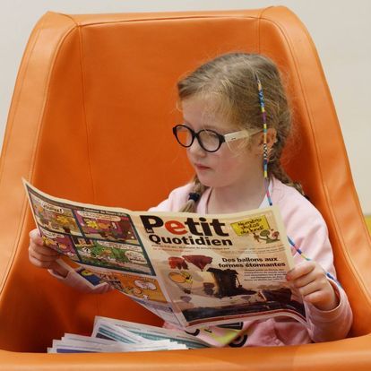 A child reading a book inside the lalloo seat