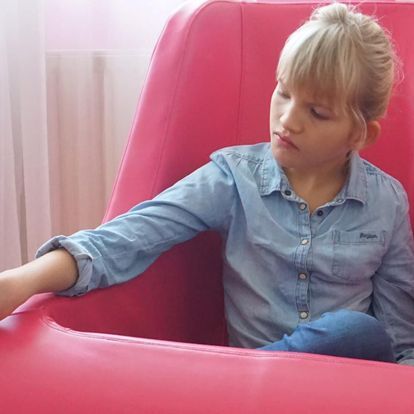 A child checking out a pink lalloo seat whilst sat inside