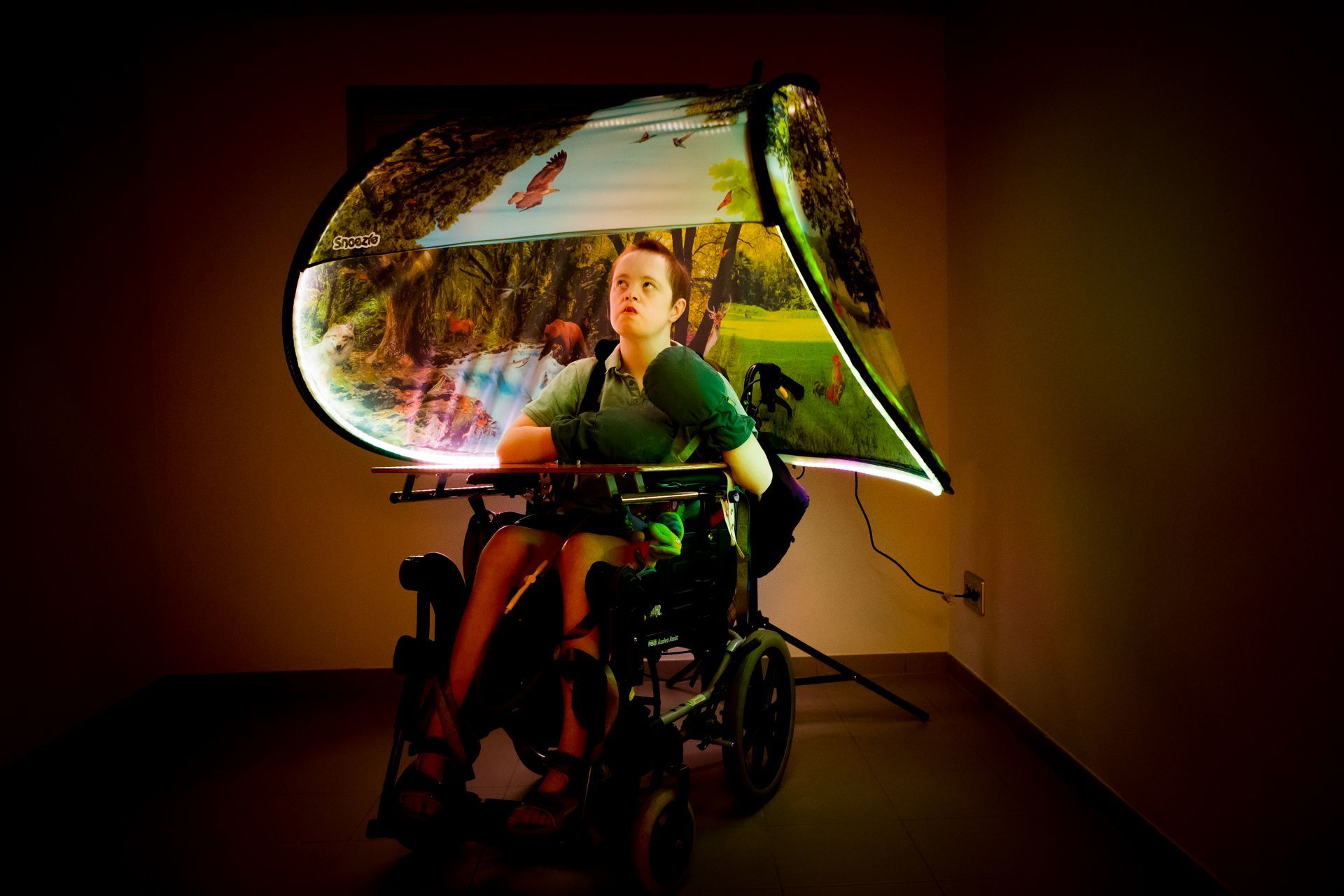 A man in a wheelchair is sitting in front of a large screen