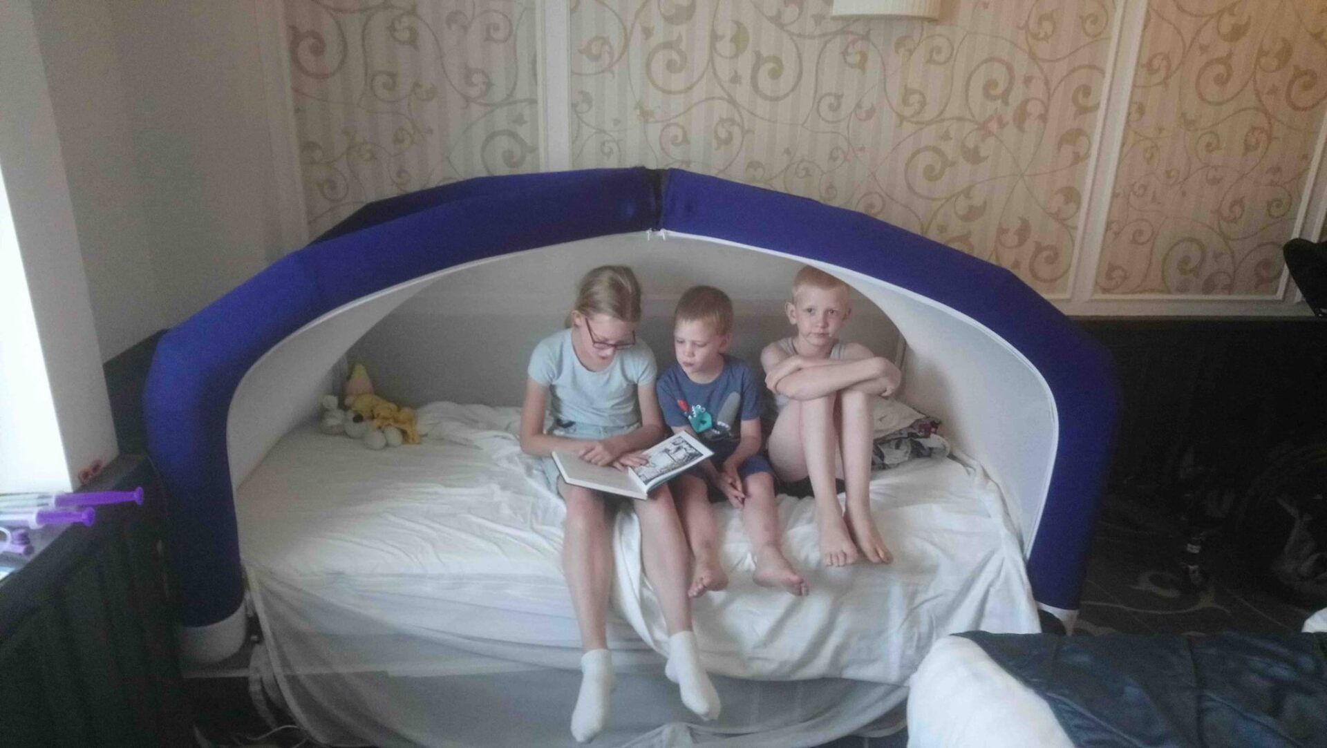 Three siblings reading book in CloudCuddle