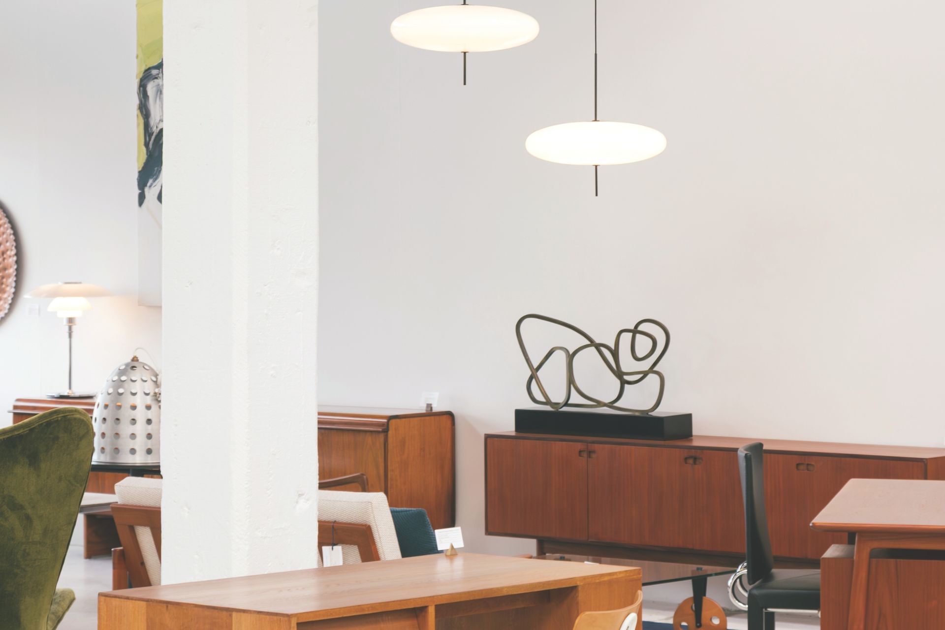 Interior of a room with mid-century modern furniture, white walls, and two pendant lights.