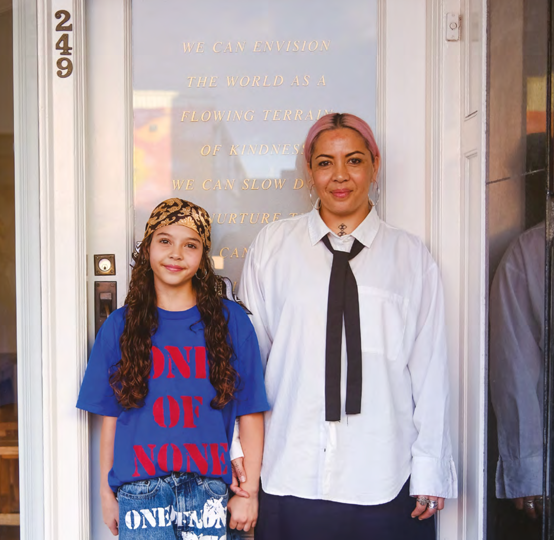 Two people standing in front of a gallery door.