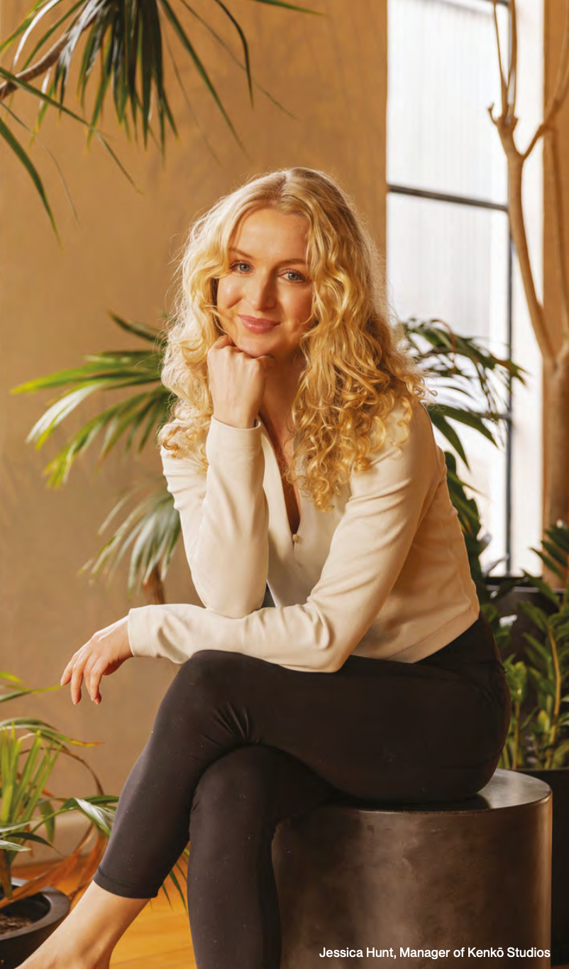 A woman is sitting on a stool with her legs crossed.