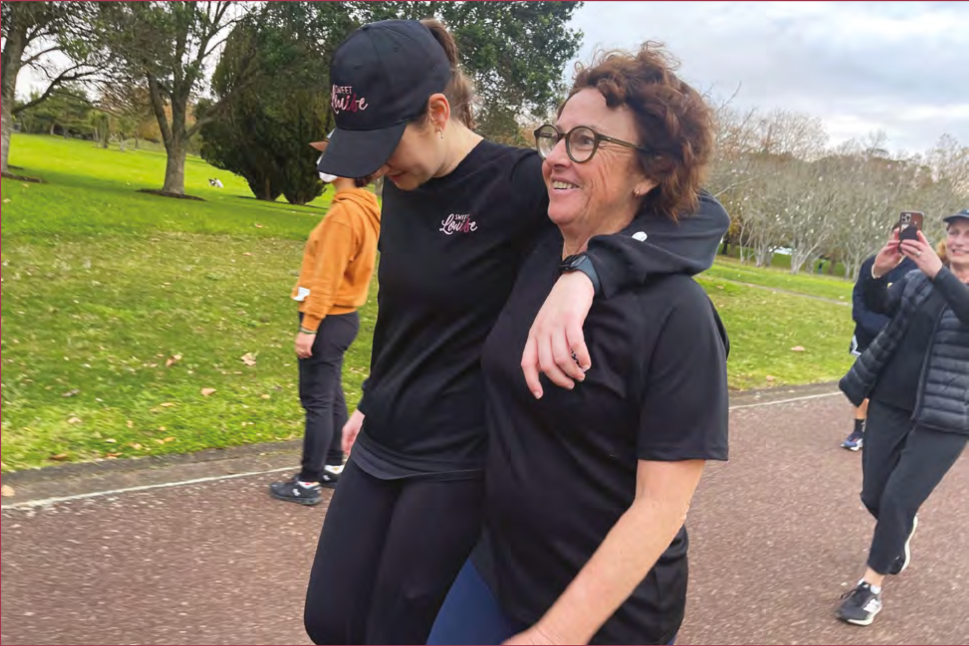 Two women walking together in a park.
